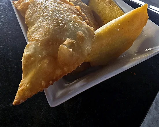 Golden fried cheese empanadas on a white square plate